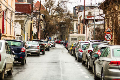 Vehicles on road amidst buildings in city