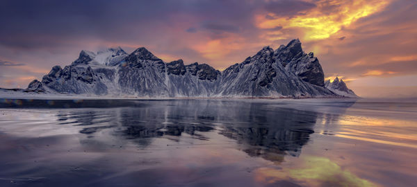 Scenic view of frozen lake against sky during sunset