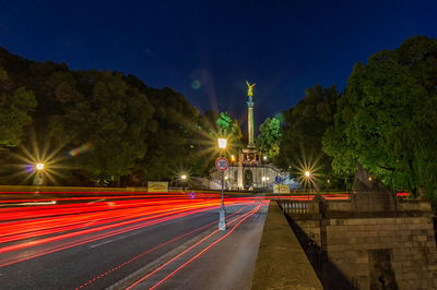 Light trails on road against sky at night