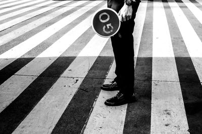 Low section of man standing on road