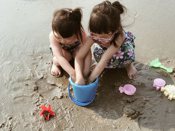 High angle view of siblings playing at beach