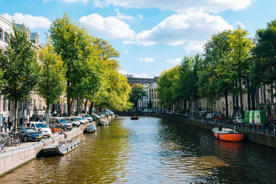 Scenic view of canal in city against sky