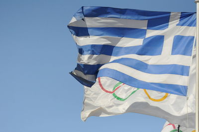 Low angle view of flag against clear blue sky