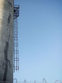 Low angle view of power lines against clear blue sky