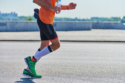 Running man. athletic man jogging in sportswear on city road. street workout, sprinting outdoor