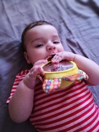 Portrait of baby boy with toy lying down on bed