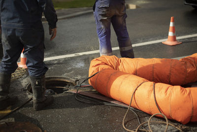 Workers and sewer hatch. road repairs. two workers opened hatch on road.