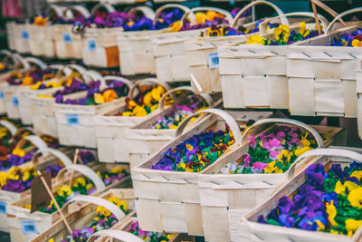 Close-up of colorful flowers in baskets for sale