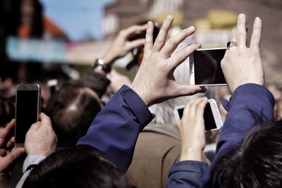 Midsection of man photographing woman using smart phone