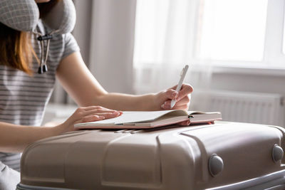 Woman writing in book at home