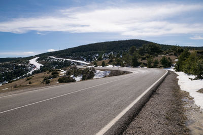 Curves on a mountain road with snow between the trees