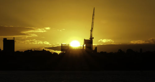 Silhouette buildings against sky during sunset