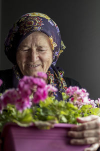 Portrait of woman with pink flowers against blurred background