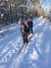 Portrait of mother and daughter skiing on snow covered land