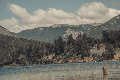 Scenic view of lake by mountains against sky