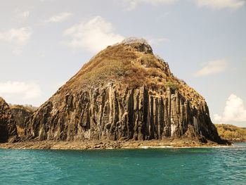 Scenic view of rock formation in sea against sky