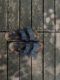 High angle view of open shoes on outdoor wooden floor in summer with leave shadow 