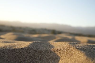Surface level of sand on desert against clear sky