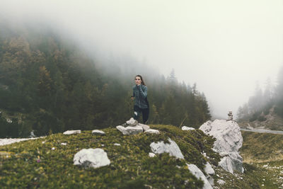 Young woman running on field during foggy weather