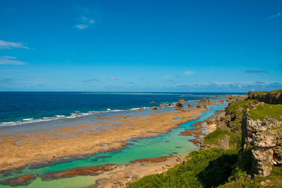 Scenic view of beach against blue sky