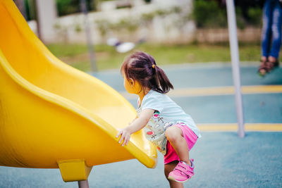 Side view of girl playing on slide
