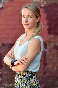 Portrait of woman standing against wall