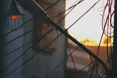 Low angle view of illuminated lighting equipment against sky during sunset