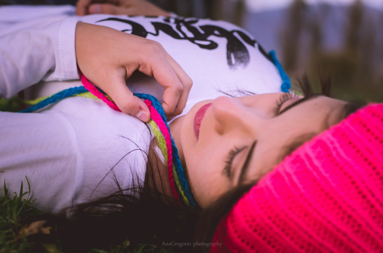 lifestyles, close-up, leisure activity, focus on foreground, midsection, casual clothing, headshot, pink color, relaxation, sensuality, human face, part of, day, selective focus
