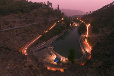 High angle view of illuminated road amidst trees at night