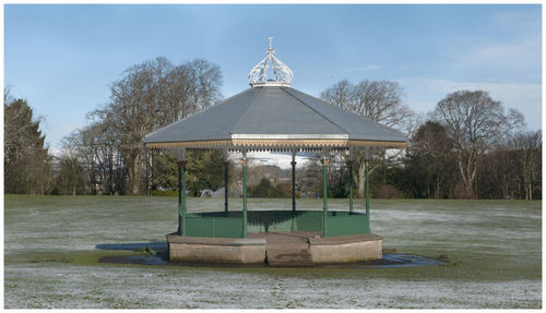 Gazebo by lake against sky