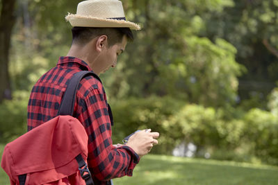 Side view of young man looking at camera