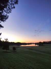 Scenic view of field against sky at sunset