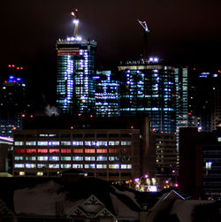 Illuminated cityscape against sky at night