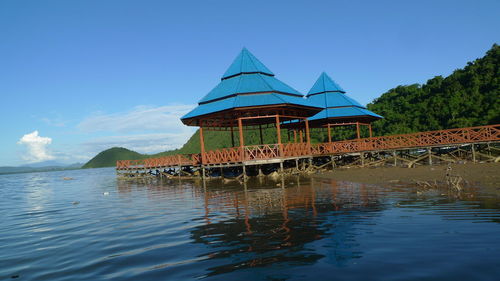 Built structure by sea against blue sky