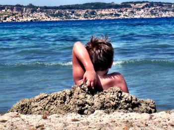 People relaxing on rocks at beach