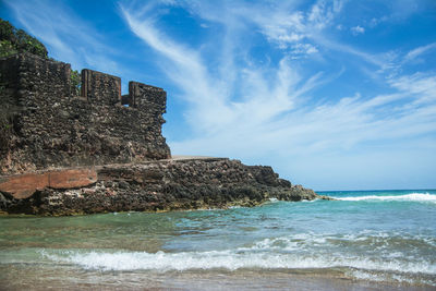 View of a beach with old stone building ruins