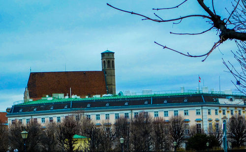 Bare trees against built structure