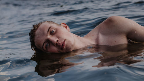 Portrait of woman lying in swimming pool