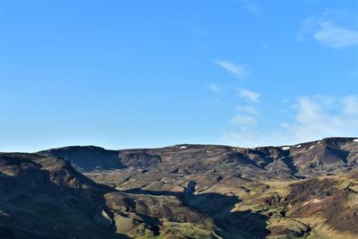 Scenic view of mountains against blue sky