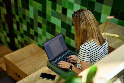 Woman using laptop in coworking. female freelancer typing on laptop keyboard. online work in cafe