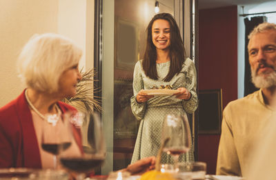 Portrait of smiling young woman standing in restaurant