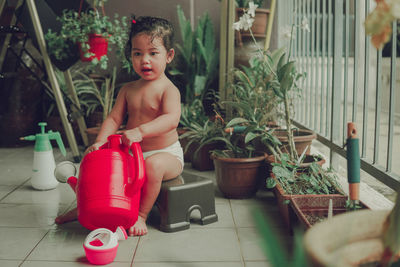 Cute boy playing in potted plants