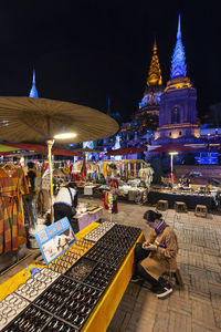 People in illuminated building at night