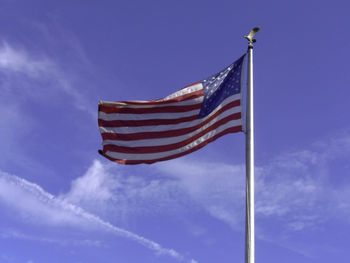 Low angle view of american flag against blue sky