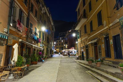 Street amidst buildings in city at night