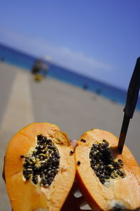 Close-up of orange slice in sea against sky