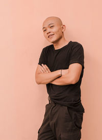 Full length of a smiling young man against wall