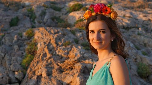 Portrait of beautiful young woman on rock