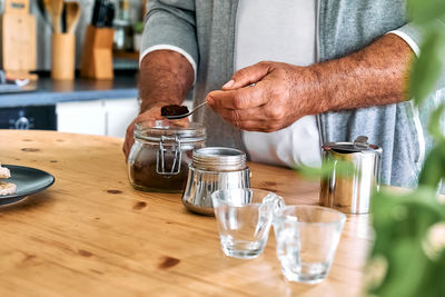 Man preparing classic italian coffee in the mocha, filling funnel of a moka pot with ground coffee. 