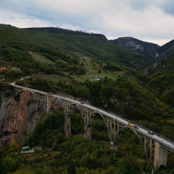 Arch bridge over mountains against sky